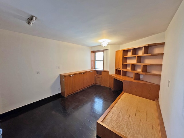 interior space featuring dark wood-type flooring and built in desk