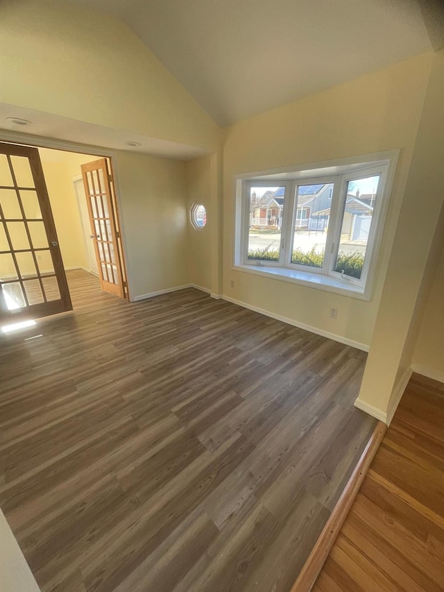 unfurnished living room with dark hardwood / wood-style flooring and lofted ceiling