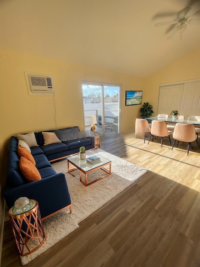 living room featuring lofted ceiling, ceiling fan, wood-type flooring, and a wall mounted air conditioner