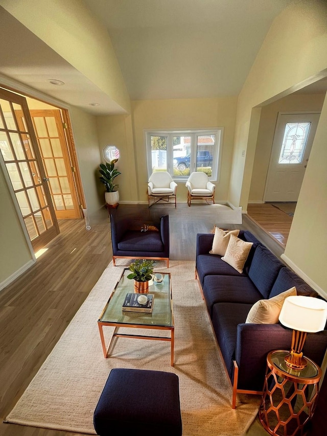 living room with french doors, hardwood / wood-style floors, and vaulted ceiling