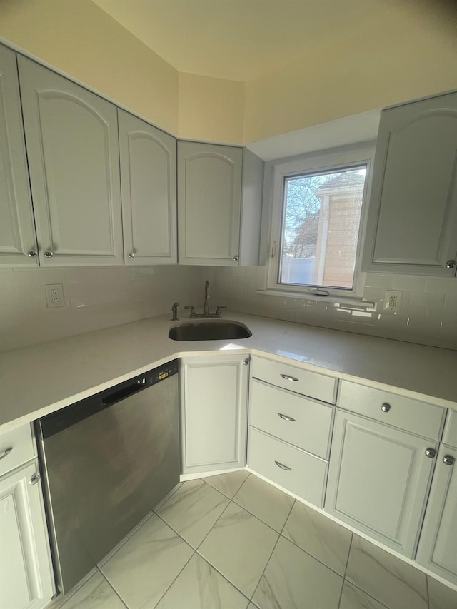 kitchen featuring dishwasher, sink, and tasteful backsplash