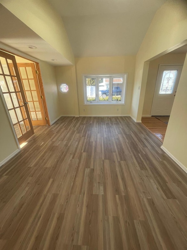 unfurnished living room with french doors, dark hardwood / wood-style flooring, and lofted ceiling