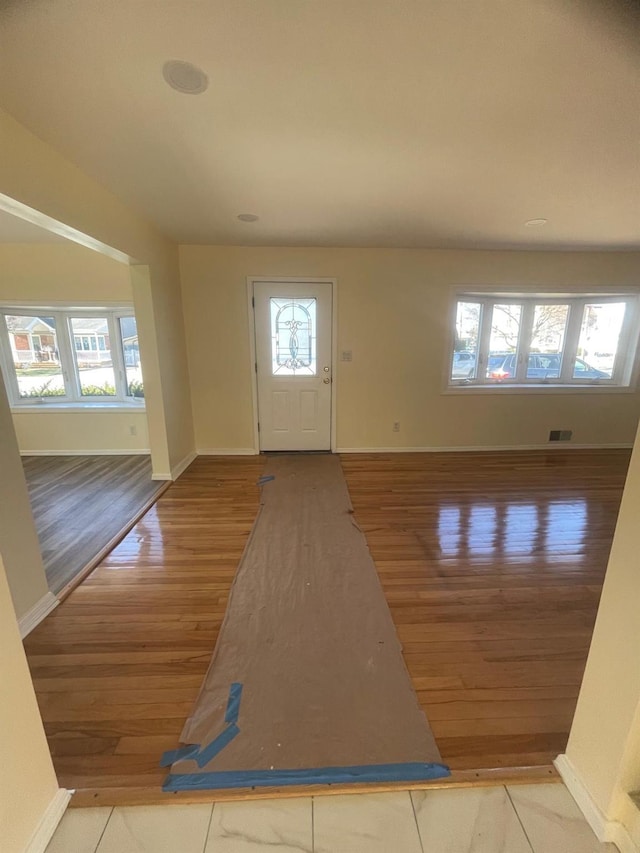 foyer entrance with wood-type flooring and a healthy amount of sunlight