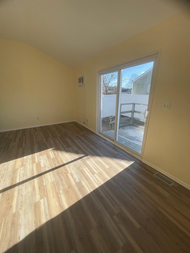 spare room with a wall mounted air conditioner and wood-type flooring