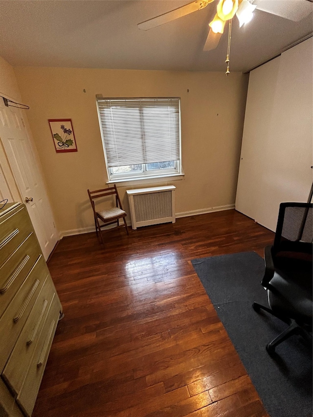 sitting room featuring radiator, dark wood-type flooring, and ceiling fan