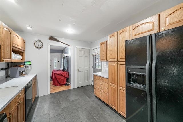 kitchen featuring light brown cabinetry and black appliances