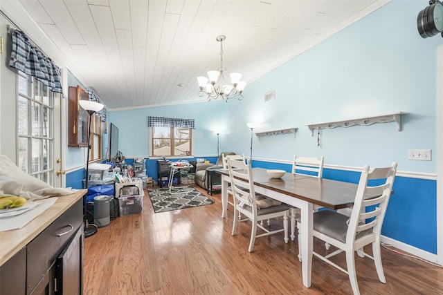 dining space featuring wood ceiling, vaulted ceiling, crown molding, light hardwood / wood-style flooring, and a notable chandelier