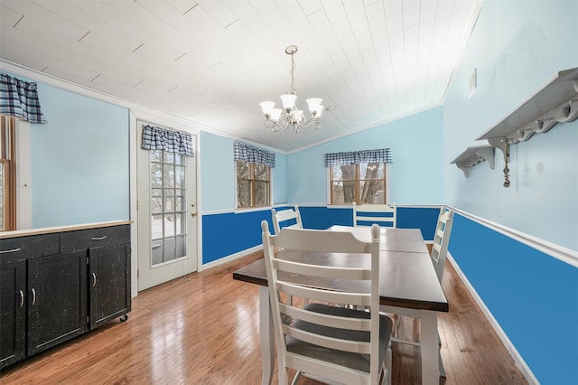 dining space featuring lofted ceiling, wooden ceiling, an inviting chandelier, hardwood / wood-style flooring, and ornamental molding