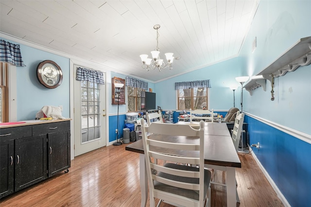 dining room featuring hardwood / wood-style floors, lofted ceiling, an inviting chandelier, plenty of natural light, and wood ceiling