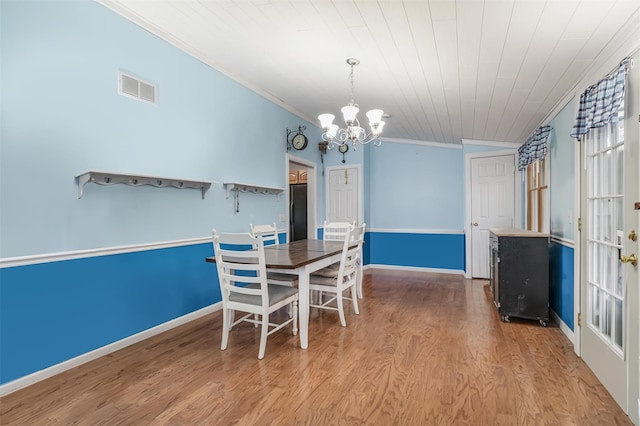 dining room featuring crown molding, light hardwood / wood-style flooring, wooden ceiling, and an inviting chandelier