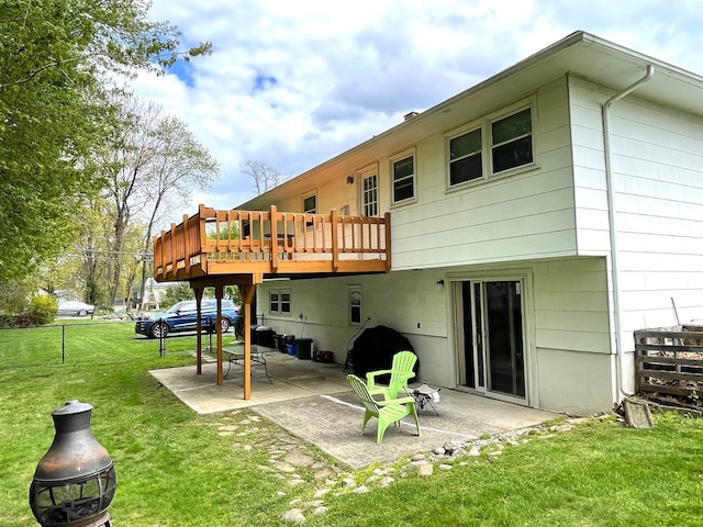 rear view of property featuring a yard, a patio, and a deck