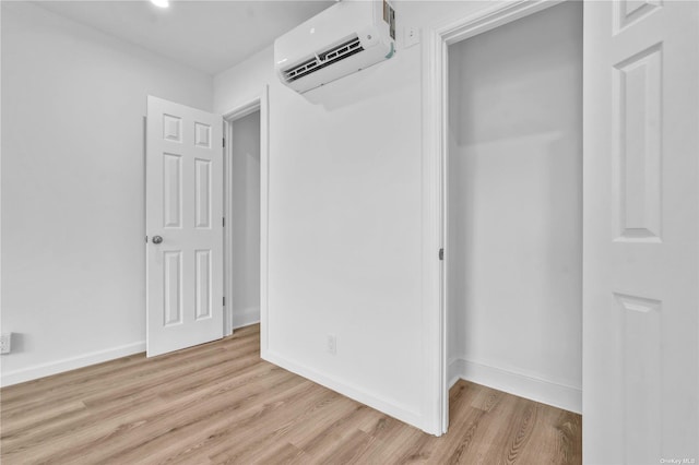 hall featuring light hardwood / wood-style floors and an AC wall unit