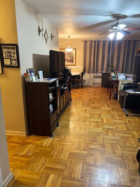 living room featuring ceiling fan and radiator