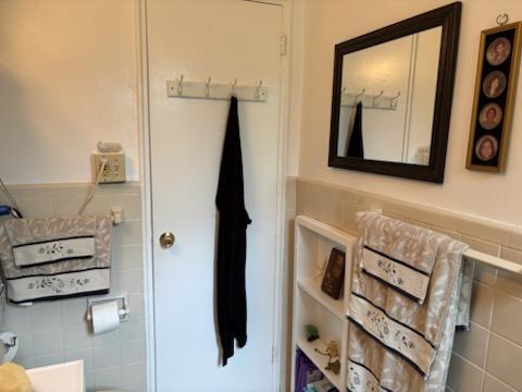 bathroom with tile walls and a wainscoted wall
