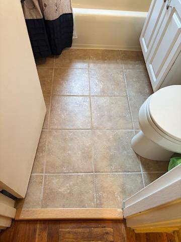 bathroom featuring tile patterned floors, toilet, and curtained shower