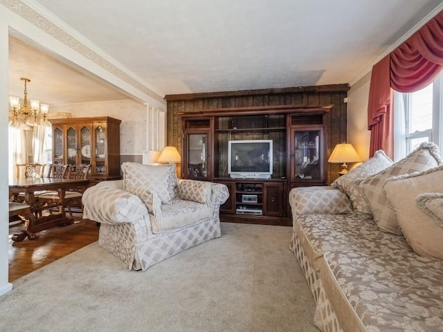 living room featuring carpet, crown molding, and a chandelier