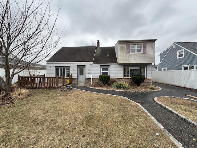 rear view of property featuring a lawn and a deck