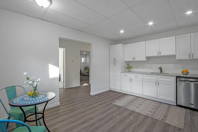 kitchen featuring a paneled ceiling, hardwood / wood-style floors, dishwasher, sink, and white cabinets