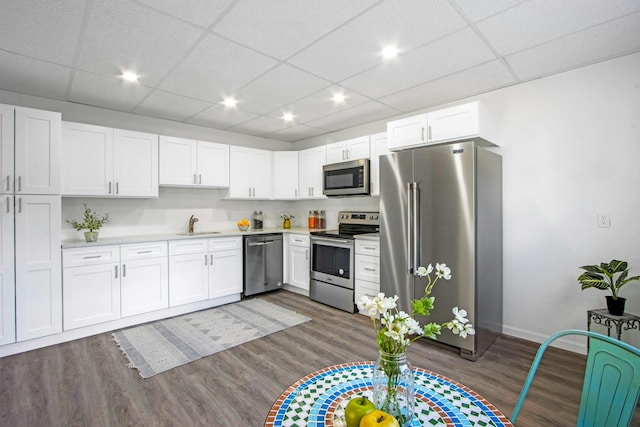 kitchen featuring stainless steel appliances, dark hardwood / wood-style floors, sink, and white cabinets