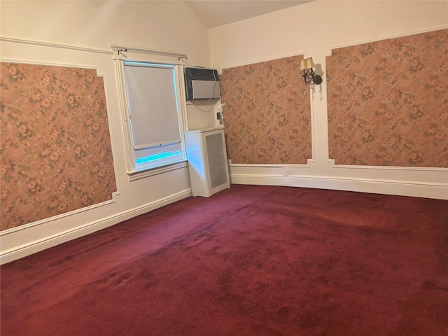 carpeted spare room with vaulted ceiling