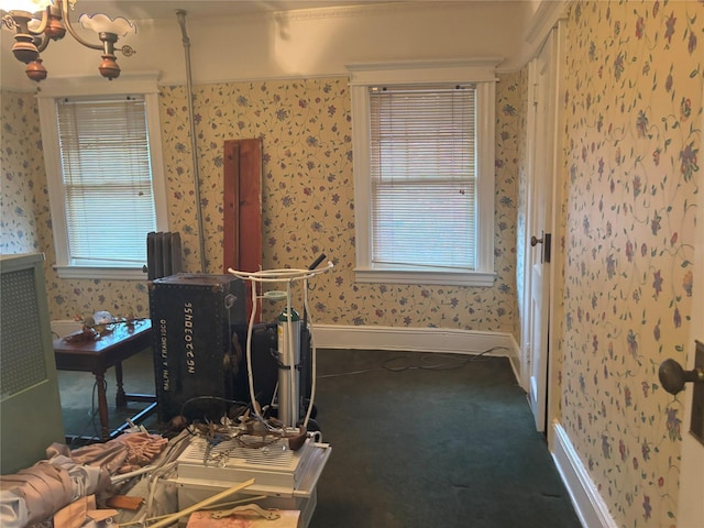 carpeted bedroom with an inviting chandelier, wallpapered walls, and baseboards