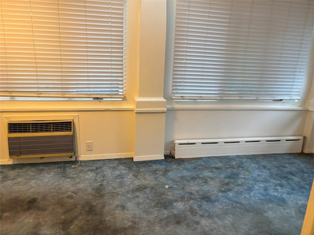 spare room featuring a wall mounted air conditioner, baseboard heating, carpet floors, and baseboards