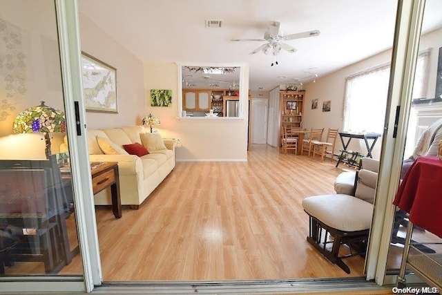 living room with ceiling fan and light hardwood / wood-style flooring