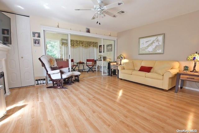 living room featuring ceiling fan and light wood-type flooring