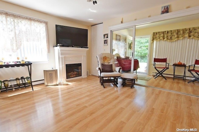 sitting room with hardwood / wood-style flooring and a baseboard radiator