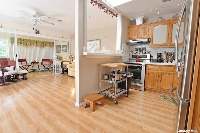 kitchen with decorative backsplash, ceiling fan, appliances with stainless steel finishes, and light hardwood / wood-style flooring