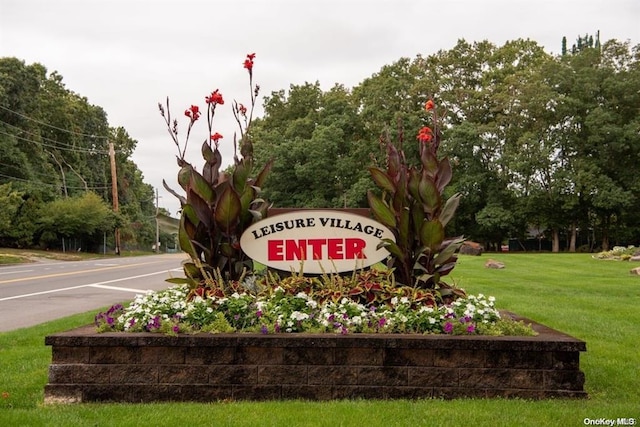 community / neighborhood sign featuring a lawn