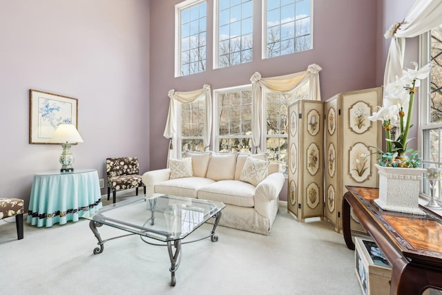 carpeted living room with a towering ceiling