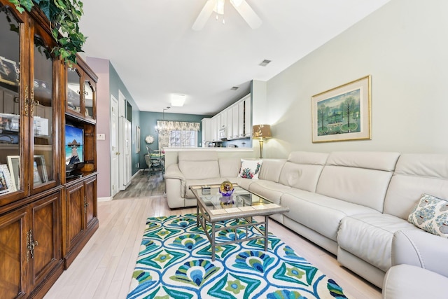 living room with ceiling fan and light hardwood / wood-style floors