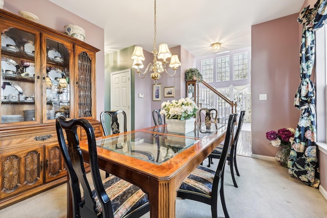 dining area with light colored carpet and a chandelier