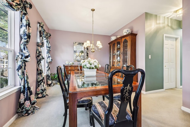 carpeted dining space featuring a chandelier