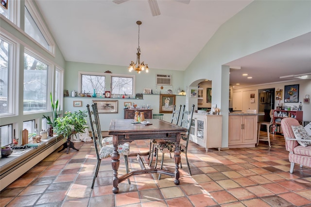 tiled dining area with vaulted ceiling, a wall unit AC, an inviting chandelier, and a baseboard heating unit