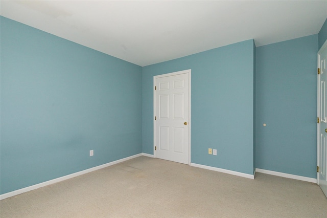 unfurnished room featuring light carpet