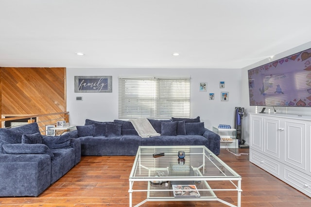 living room with wood-type flooring and wooden walls