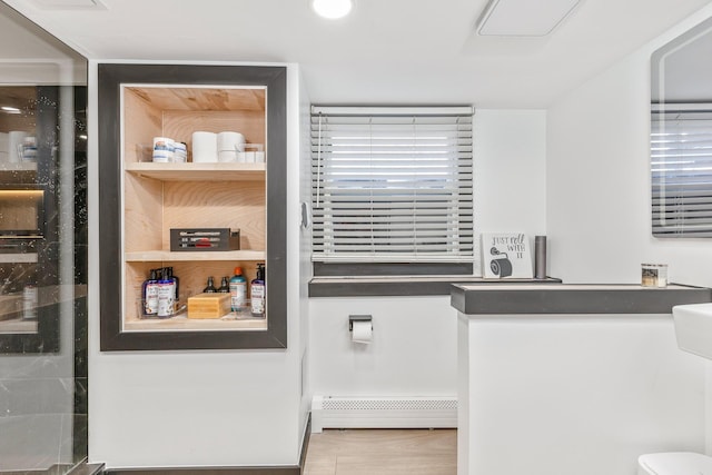 interior space with toilet and a baseboard radiator