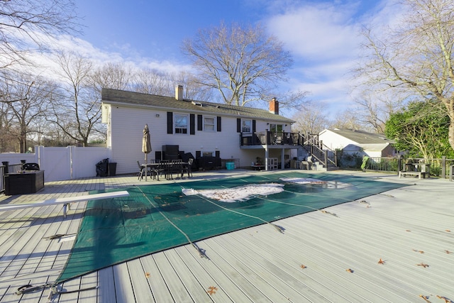 view of pool featuring a patio area, a wooden deck, and a diving board