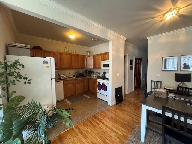 kitchen featuring white appliances, ornamental molding, and hardwood / wood-style floors