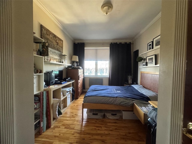 bedroom with ornamental molding and light hardwood / wood-style floors