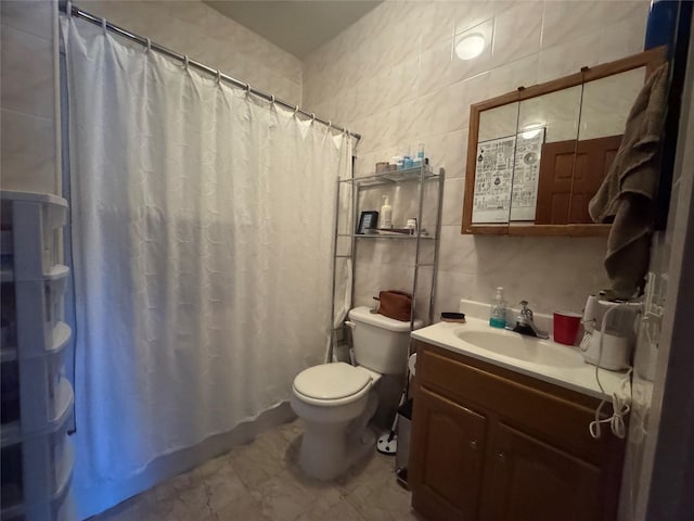 bathroom with tile walls, toilet, a shower with curtain, and vanity