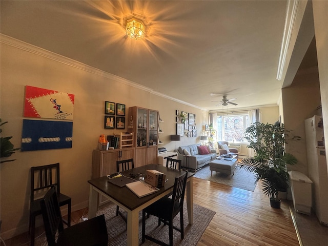 dining space featuring ornamental molding, ceiling fan, and hardwood / wood-style flooring