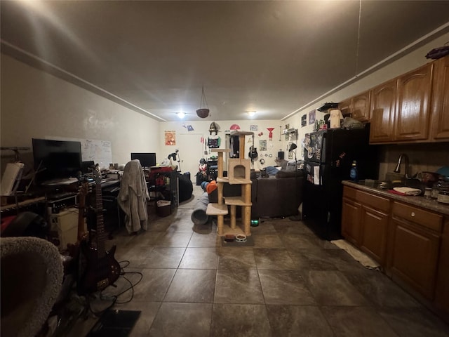 kitchen featuring sink, black fridge, and dark tile patterned floors