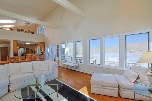 living room with high vaulted ceiling, light hardwood / wood-style flooring, baseboard heating, a mountain view, and ceiling fan