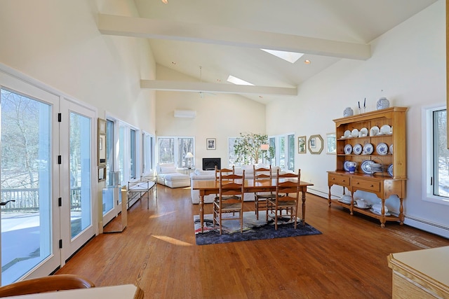 dining room with wood-type flooring, a wall mounted air conditioner, beam ceiling, and a skylight