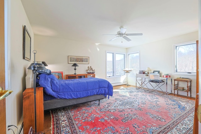 bedroom featuring baseboard heating and hardwood / wood-style flooring