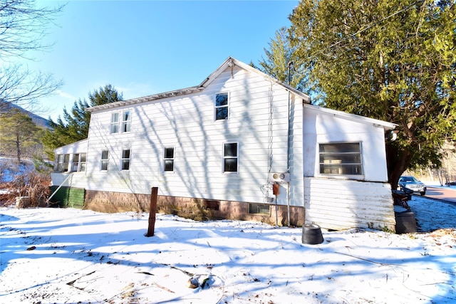 view of snow covered back of property