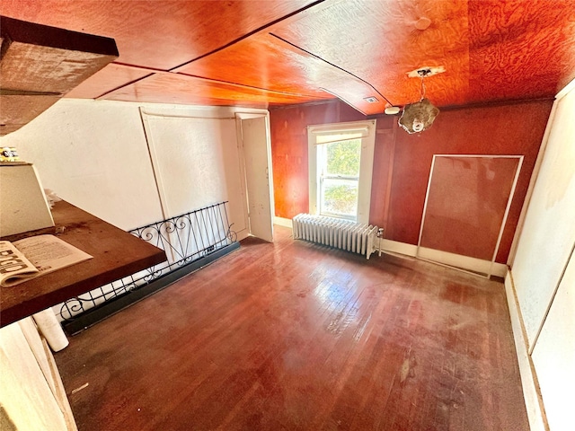 additional living space featuring wood ceiling, wood-type flooring, and radiator